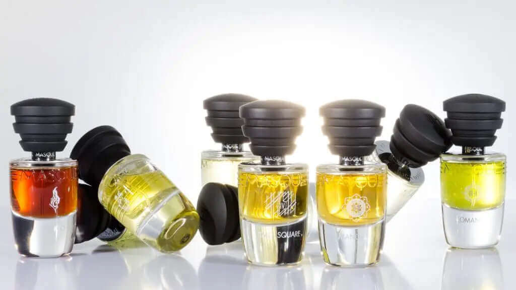 Masque Milano parfymesett med flere fargerike flasker på en reflekterende overflate