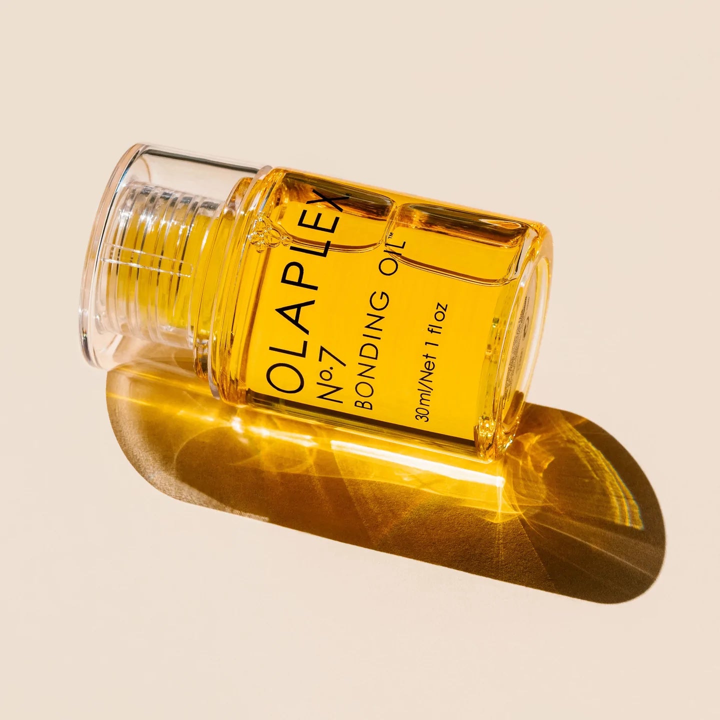 Olaplex No. 7 Bonding Oil bottle on a light background, showcasing its bright yellow color and sleek design for hair care.